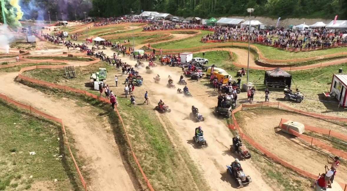 Une autre photo du départ (façon Le Mans, ou les pilotes sont alignés genoux à terre puis corus vers leurs machines) des 24h d'endurance tondeuses édition 2026